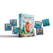 Acvarium társasjáték doboza és körülötte elhelyezett akváriumkártyák, változatos halakkal.