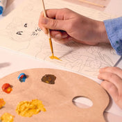 Atelier 22 műtermi festés felnőtteknek – Részletkép festés közben: ecsettel sárga festék felvitele a számozott mintára.