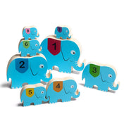A Cirkuszi elefántok! Készségfejlesztő játék, BS Toys fából készült elefántjai különböző méretekben és színekben, sorrendben elhelyezve.