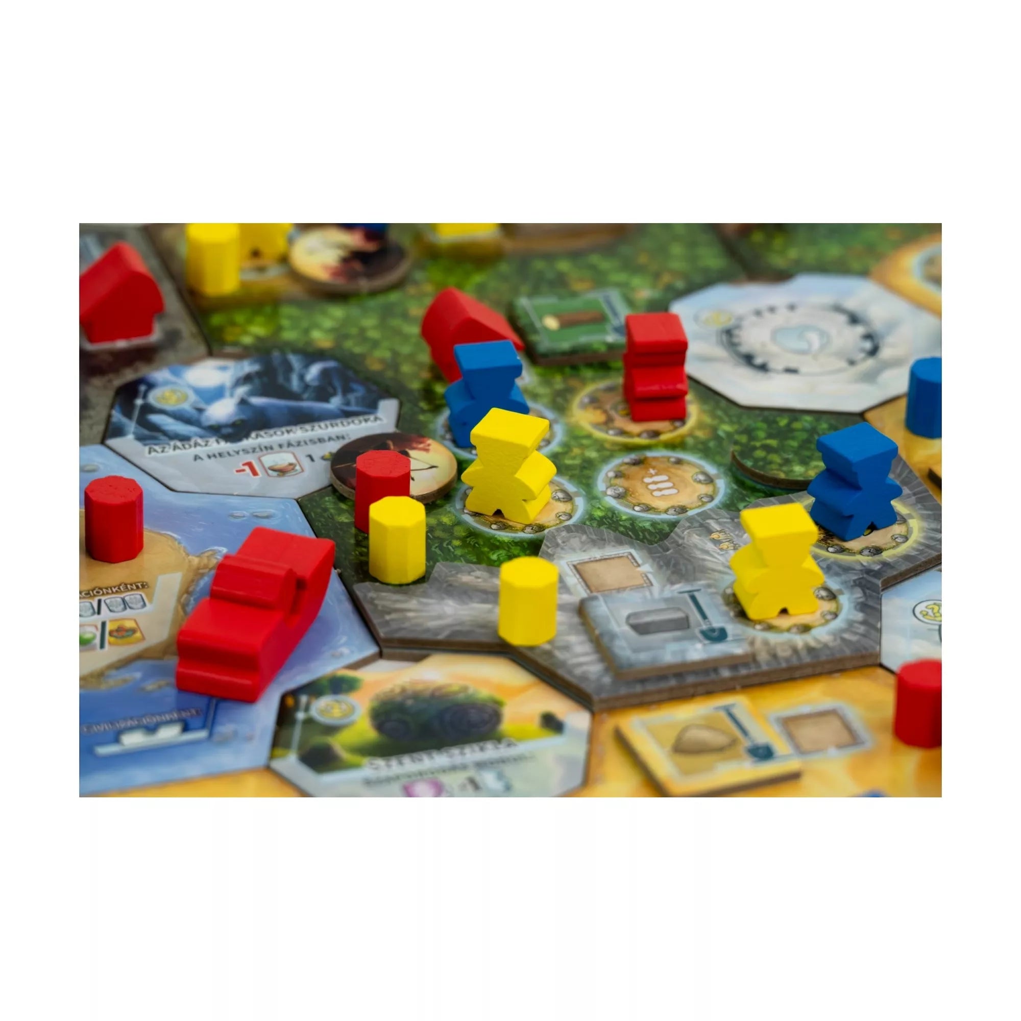 Közelkép a Civolution játéktáblájáról, ahol piros, sárga és kék fafigurák és házak állnak a különböző területeken, szimbolizálva a civilizációk terjeszkedését.