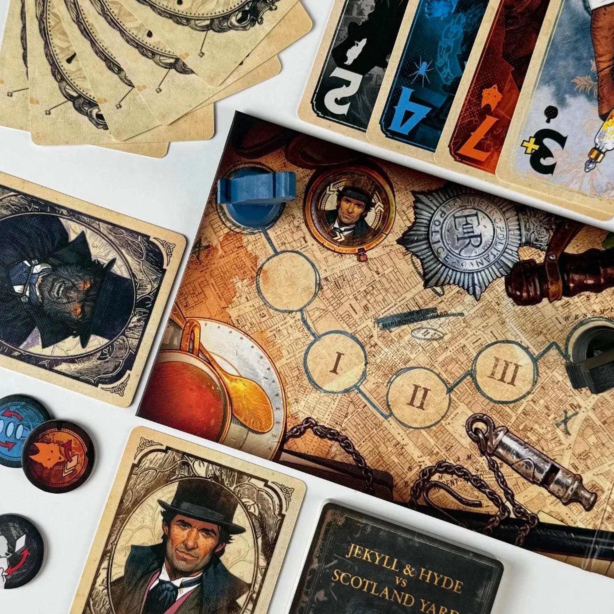 Dr. Jekyll és Mr. Hyde kártyái, valamint a játéktábla és különböző jelölők láthatók közelről. A részletgazdag illusztrációk a viktoriánus London hangulatát keltik életre.