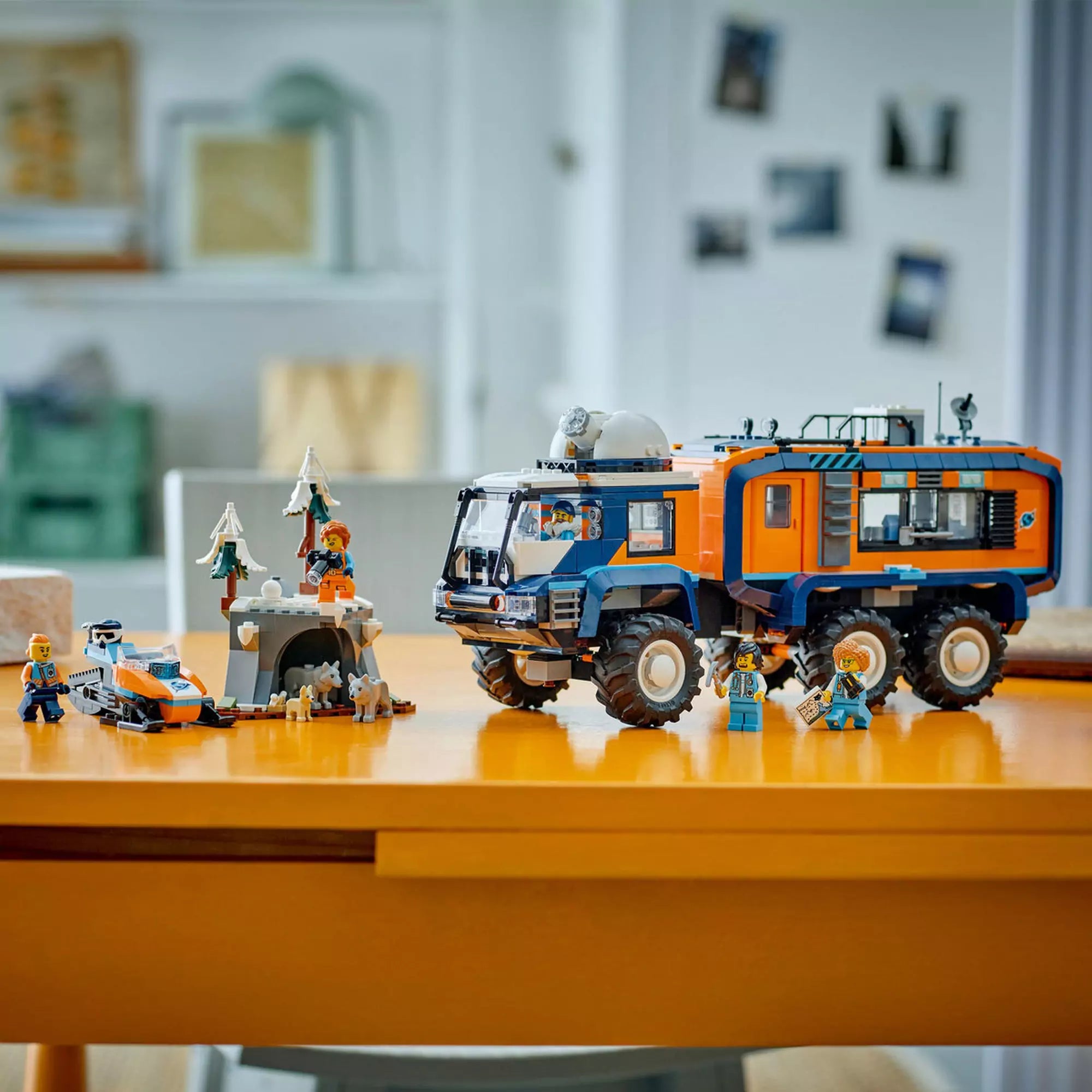 Teljesen felépített LEGO City Arctic Truck (60471) jelenet: hószán, farkasos barlang, minifigurák és a kutató jármű az asztalon.