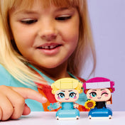 LEGO Disney Mini Anna és Elsa 43284 – Gyermek mosolyogva játszik az Anna és Elsa LEGO figurákkal közelről.