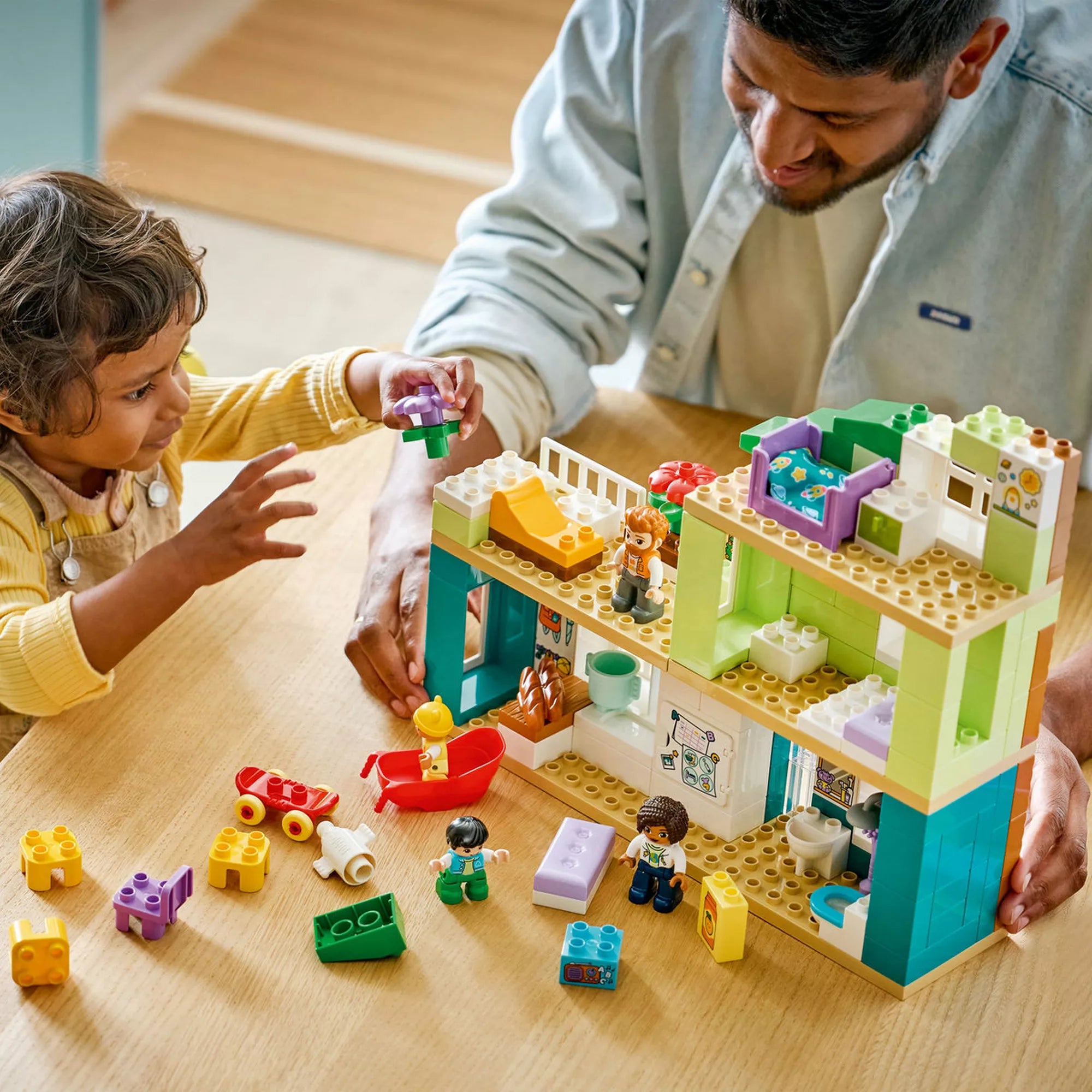 LEGO® DUPLO® Modern családi ház játék közben, kisgyermek virág elemet helyez el a tetőkertben, kreatív építés és finommotoros fejlesztés