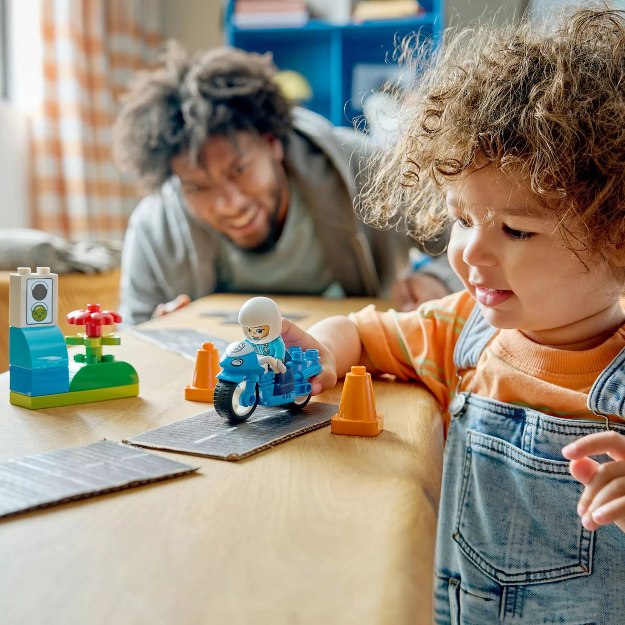 Kék rendőrségi motorkerékpár (10471) – Életkép, ahol egy kisgyermek a rendőrségi motorkerékpárral játszik bóják között.
