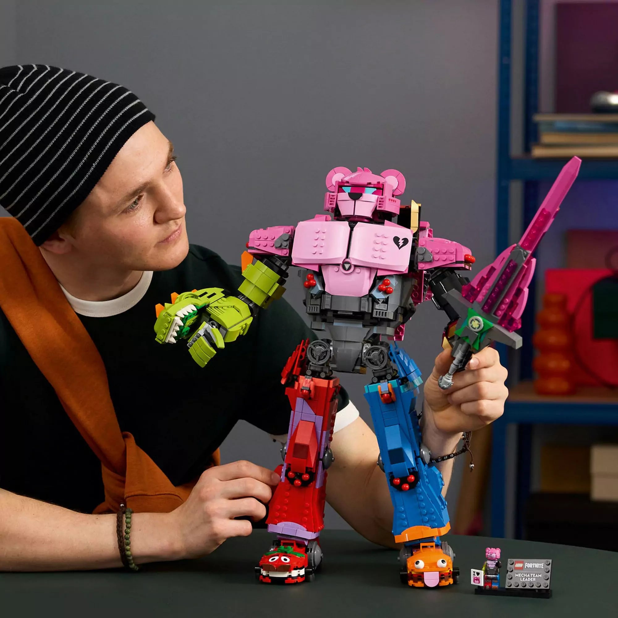 Egy fiatal felnőtt kézben tartja a LEGO Fortnite Mecha Team Leader (77078) robotot, kiemelve a méretét és részletgazdag kialakítását.