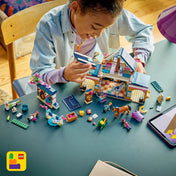 Gyermek LEGO Friends Lovasistálló és lovasakadémia készlettel játszik, az istálló építése közben, lovakkal, minibabafigurákkal és lóápolási kiegészítőkkel.