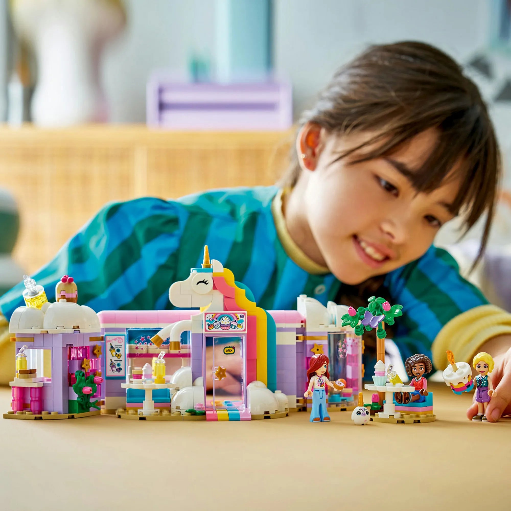 Gyermek LEGO Friends Unikornisos kávézó készlettel játszik, kávézó épülettel és figurákkal