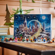 LEGO Harry Potter Adventi naptár 2025 kinyitott állapotban, a téli Roxfort illusztráció előtt felállítva az összes minifigurával és kiegészítővel.