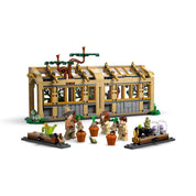 LEGO Harry Potter Roxfort kastély: Gyógynövénytanóra 76445 teljes készlet minifigurákkal, mandragórákkal és üvegházzal fehér háttér előtt.