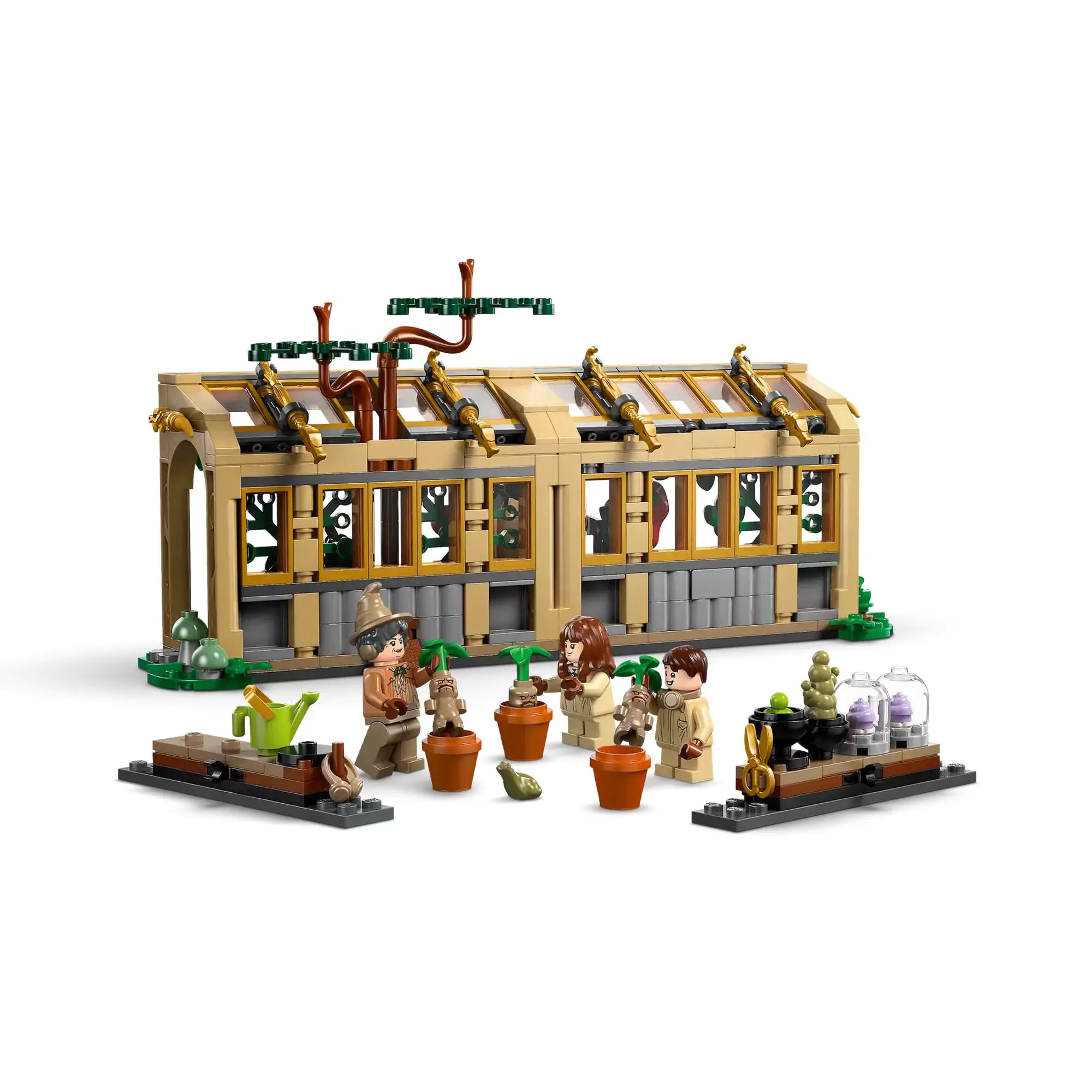 LEGO Harry Potter Roxfort kastély: Gyógynövénytanóra 76445 teljes készlet minifigurákkal, mandragórákkal és üvegházzal fehér háttér előtt.