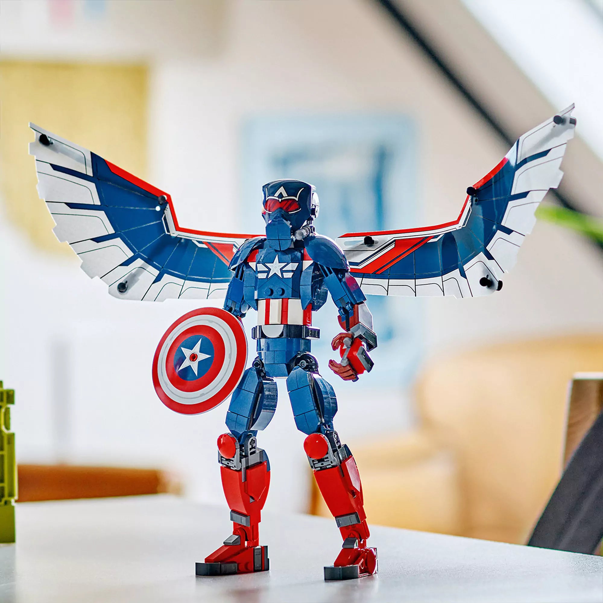  LEGO Marvel Az új Amerika Kapitány építőfigura (76296) játék közben, a figura teljes szárnyszélességgel kiállítva egy asztalon.