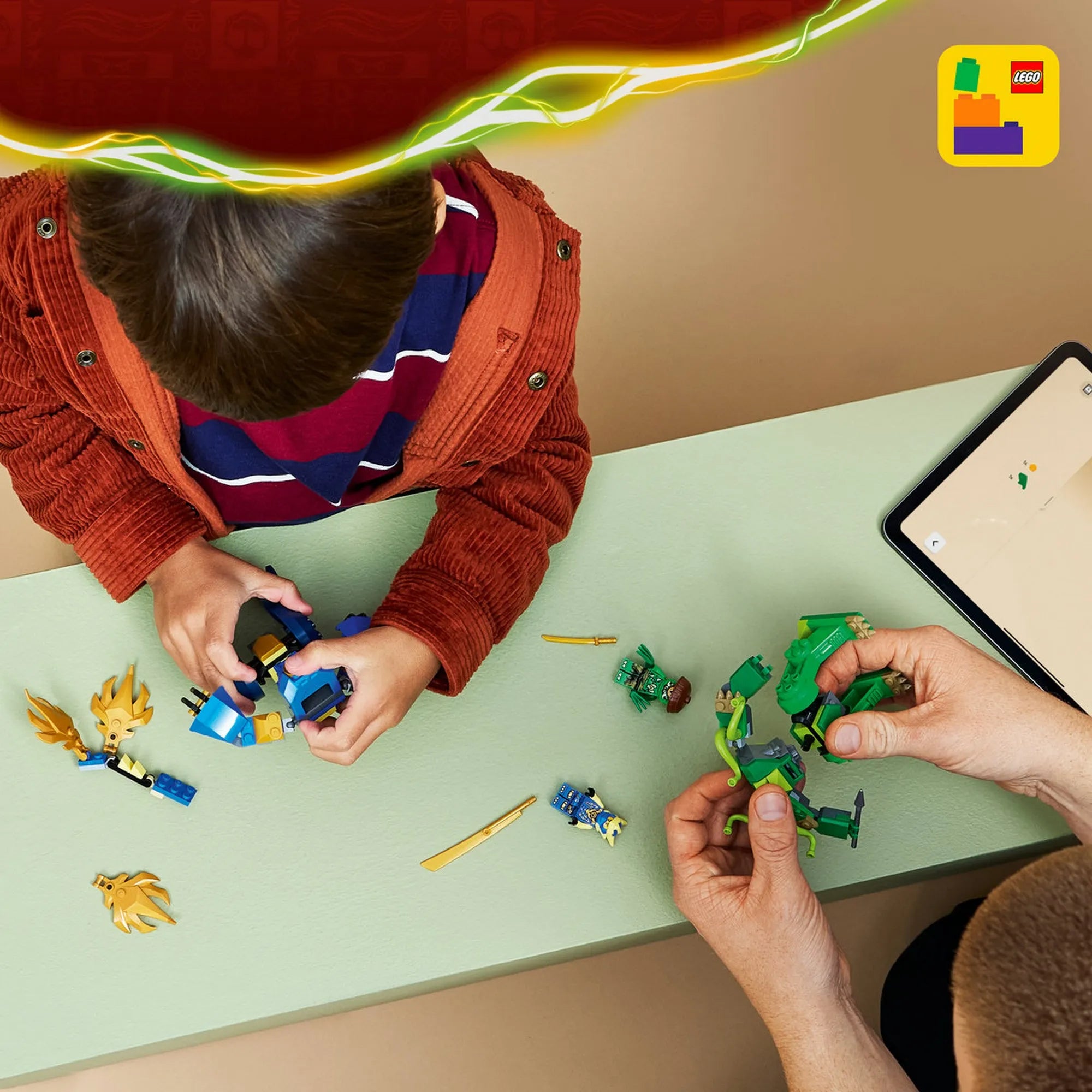 Gyerek és felnőtt együtt építik a LEGO NINJAGO 71853 készlet robotjait az asztalon.