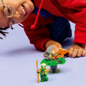 Gyermek játék közben a LEGO NINJAGO Lloyd vs. Föld Szörny pörgettyű készlettel, indítóval és minifigurákkal.