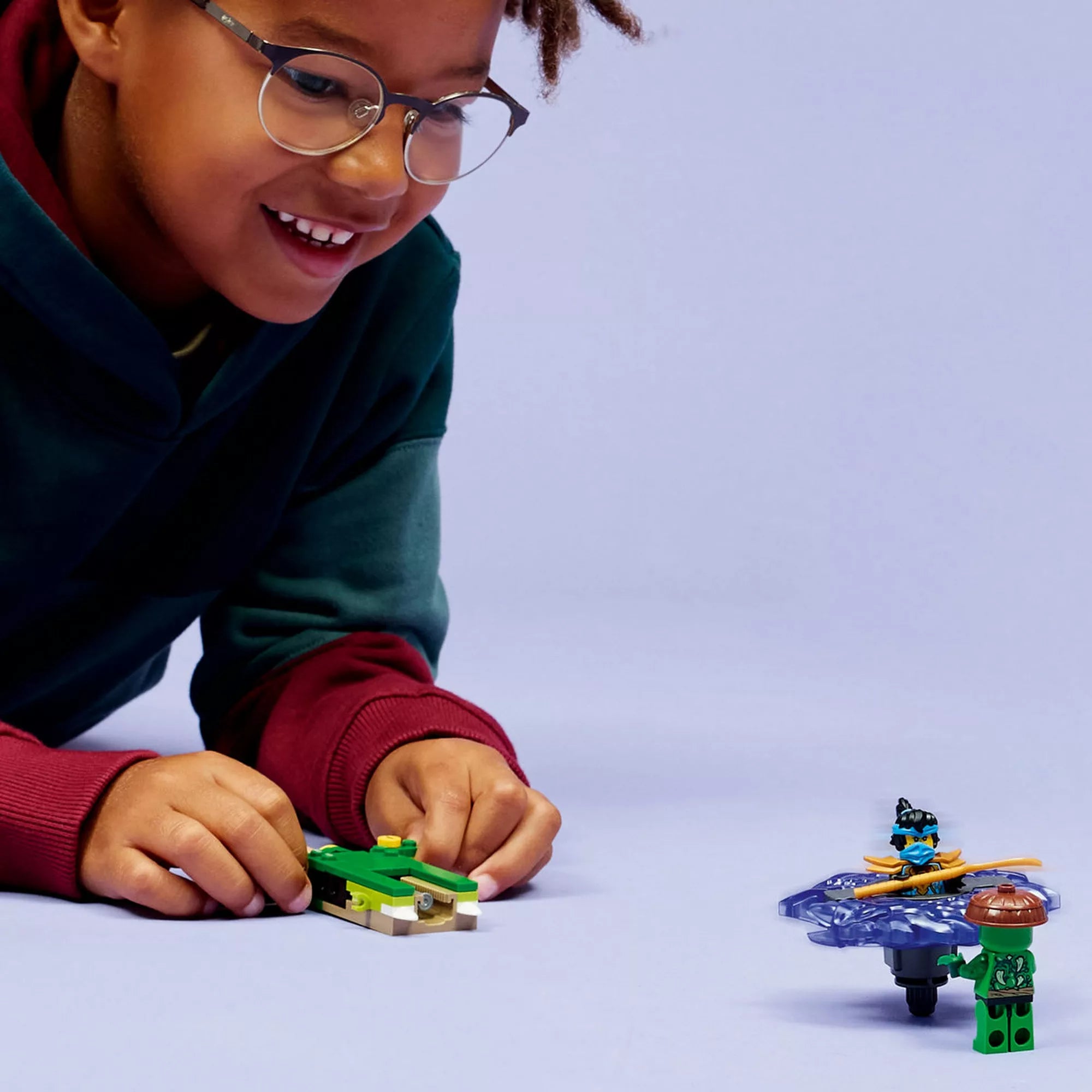 Gyermek LEGO NINJAGO Nya vs. Mutation Monster Spinner készlettel játszik, spinner kilövő és minifigurák használatával.