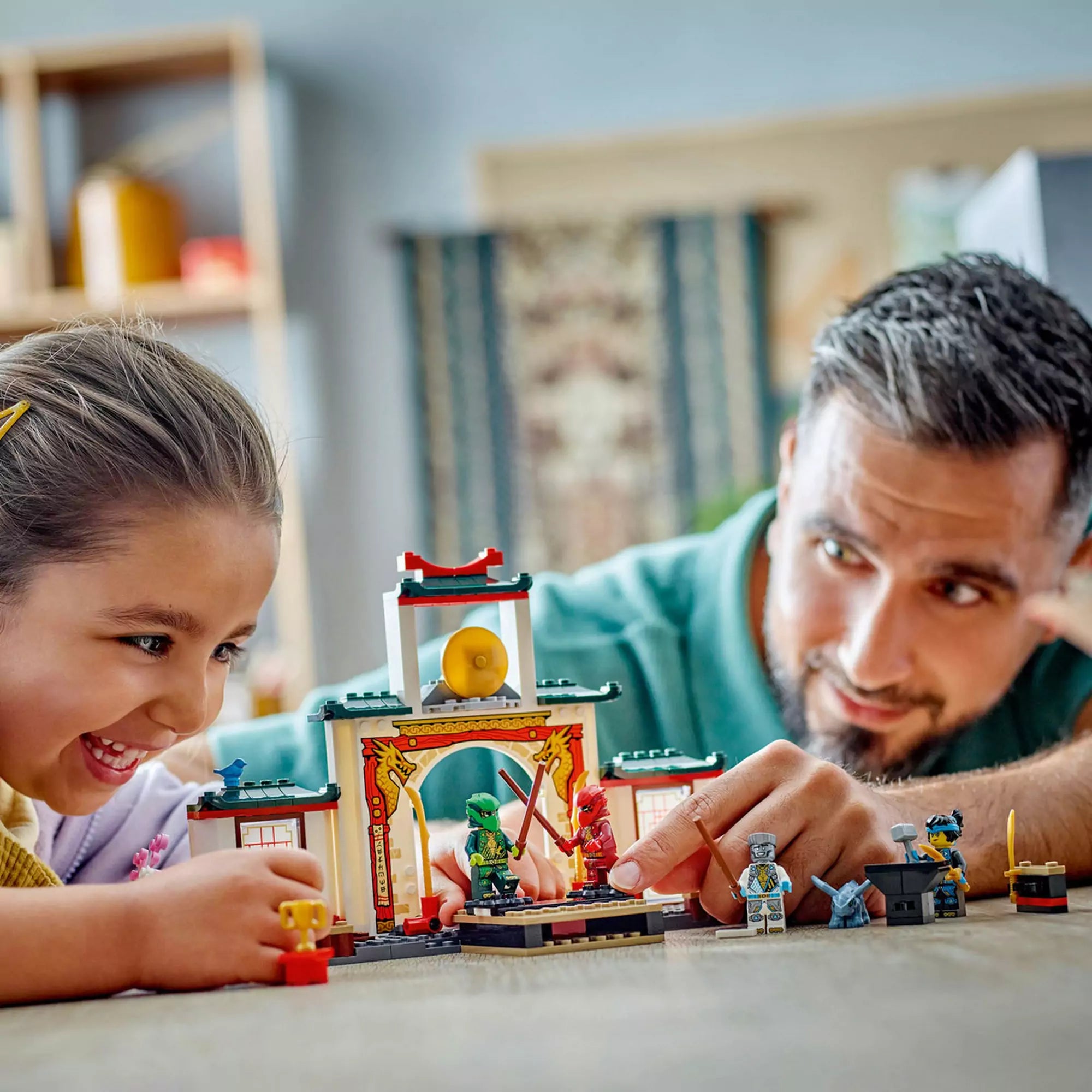 Egy kislány és egy apa játszanak a LEGO Ninjago Spinjitzu nindzsatemplom 71831 készlettel, közös élményt nyújtva.