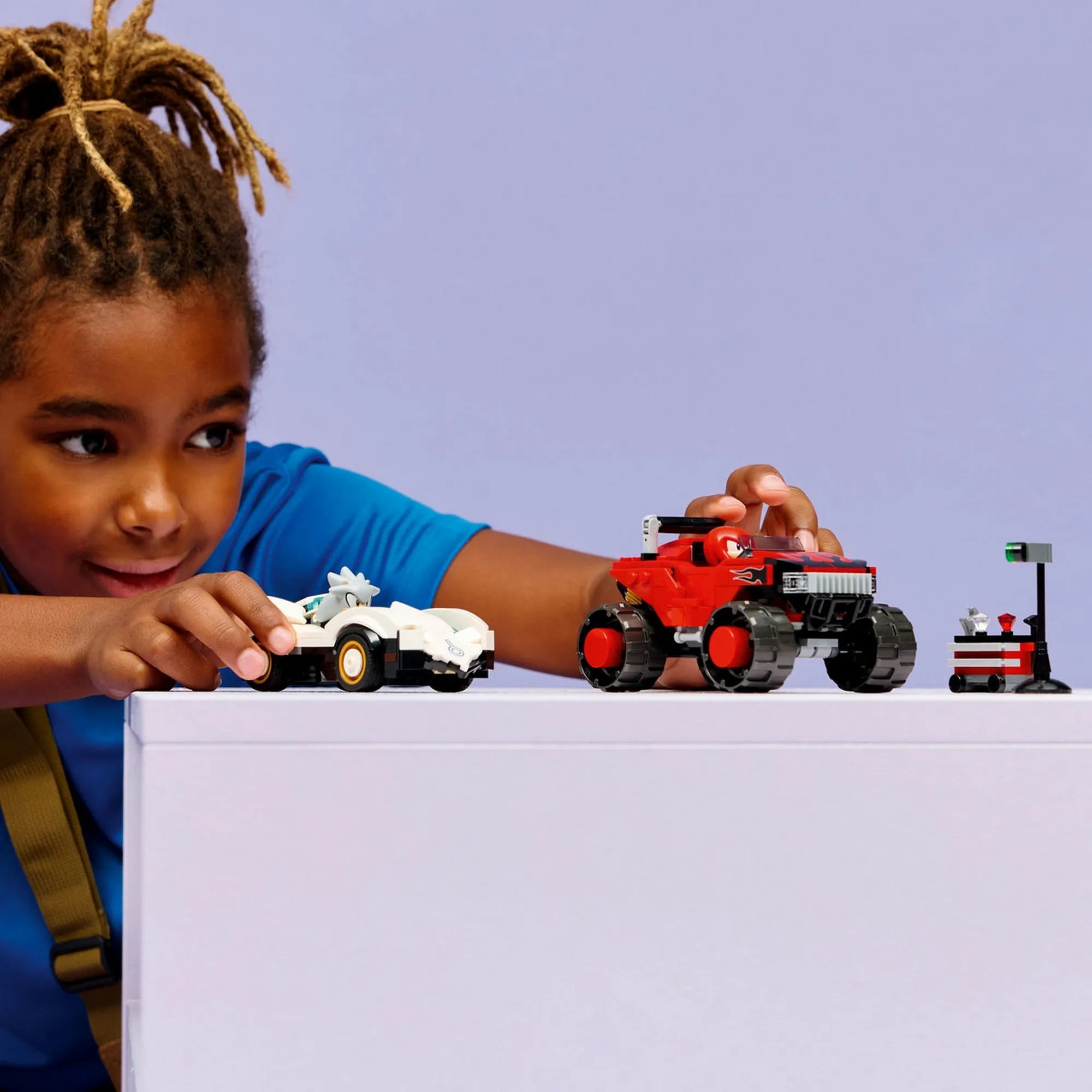 Gyermek játék közben a LEGO Sonic the Hedgehog: Silver autója Knuckles monster truckja ellen, 77118, 378 darabos készlet járműveivel.