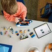 Gyermek építi a LEGO Sonic the Hedgehog 77006 Team Sonic parancsnoki kamiont, a figurák és alkatrészek az asztalon sorakoznak.