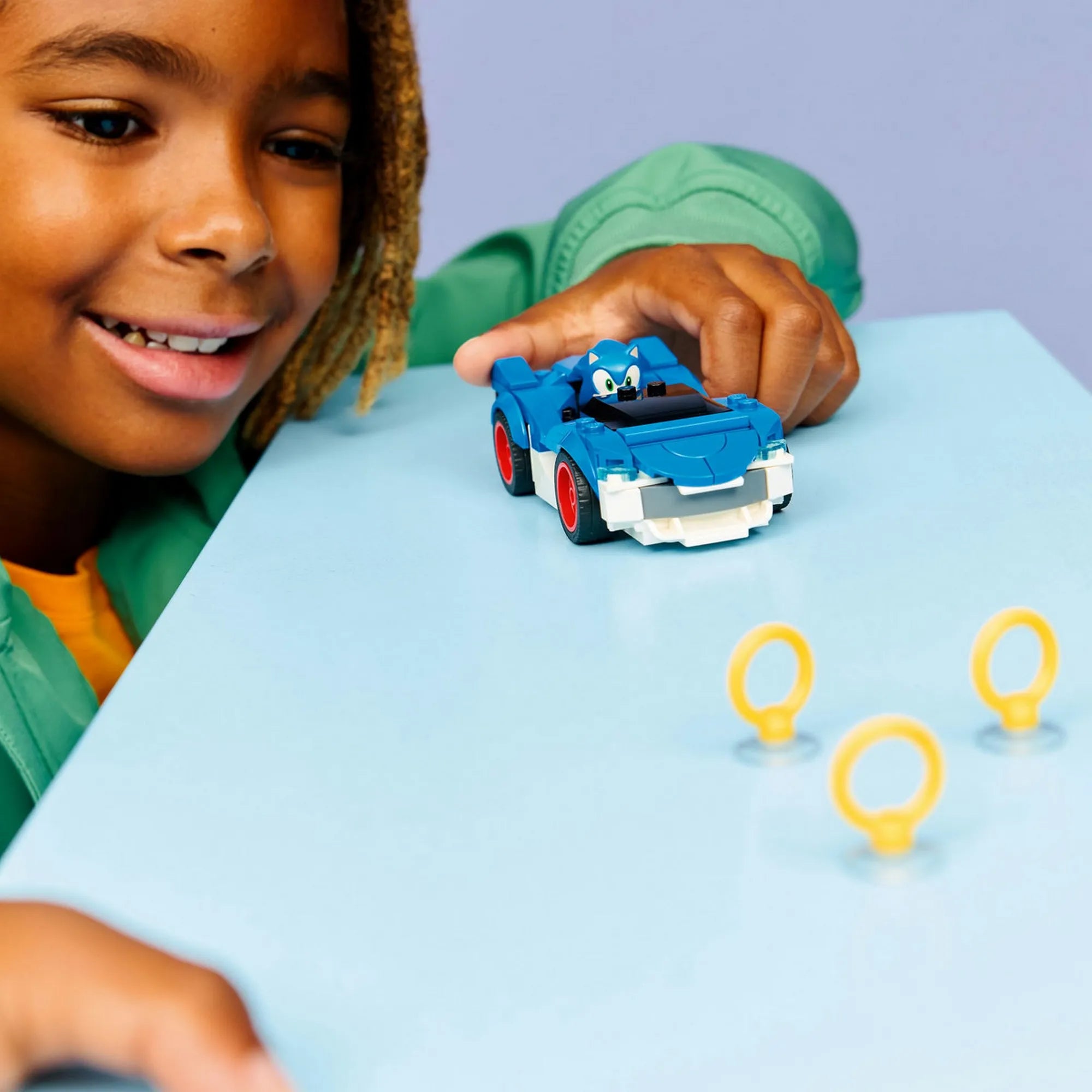 LEGO Sonic the Hedgehog Sonic Speedster Lightning (77117) játékkészlet használat közben, Sonic autója arany gyűrűk mellett.