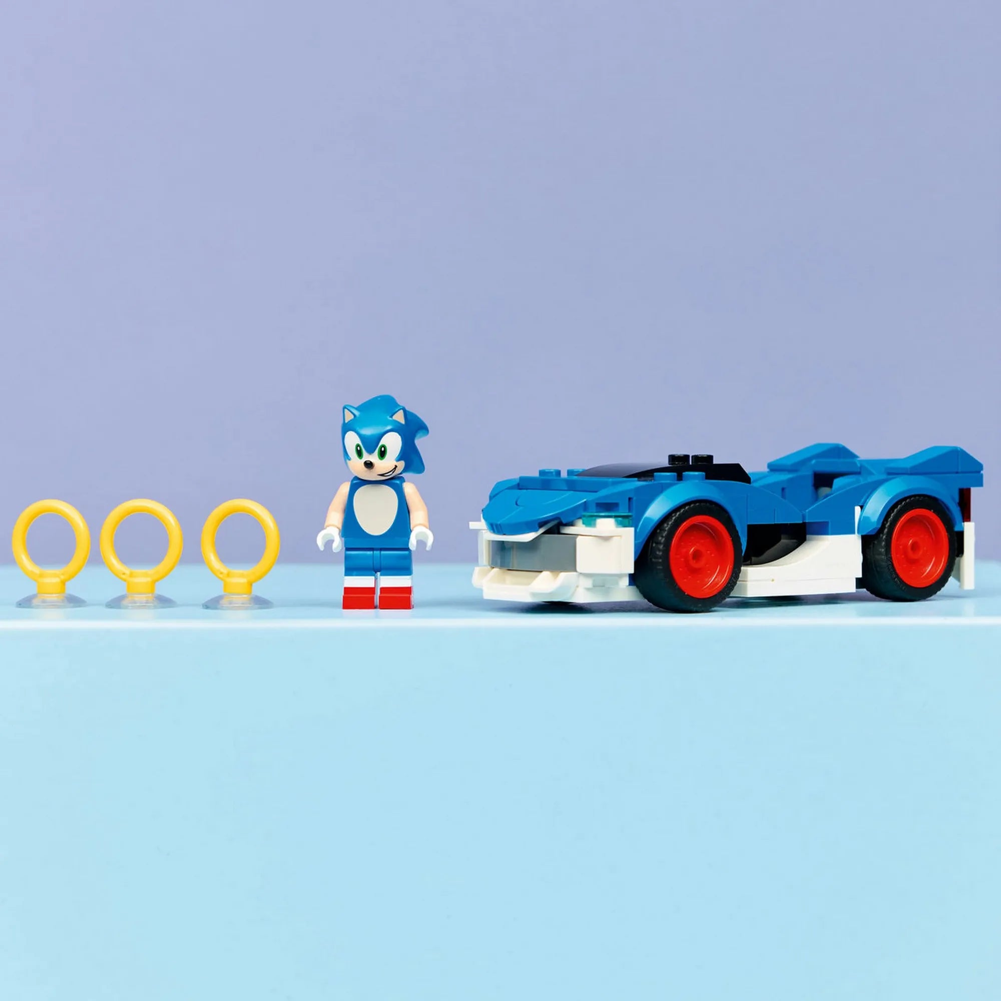 LEGO Sonic the Hedgehog Sonic Speedster Lightning (77117) készlet elemei: Sonic minifigura, kék versenyautó és arany gyűrűk.