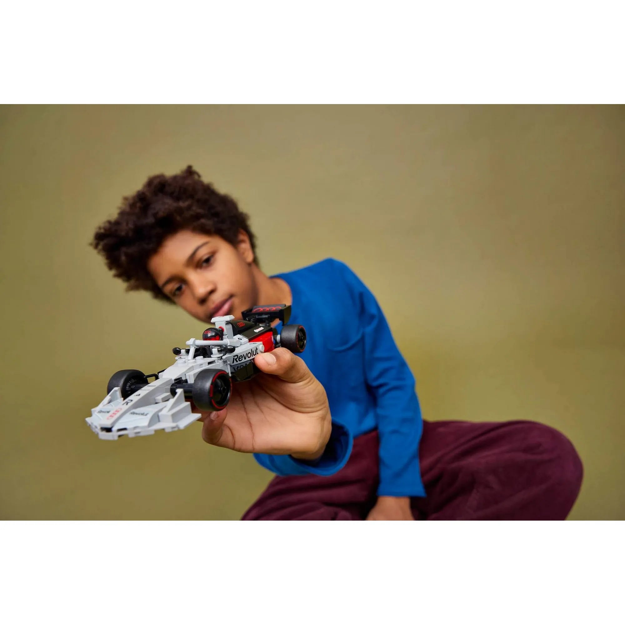 Gyerek LEGO Speed Champions Audi Revolut F1 Team R26 versenyautó modellel játszik, kézben tartott Formula 1 LEGO autó.