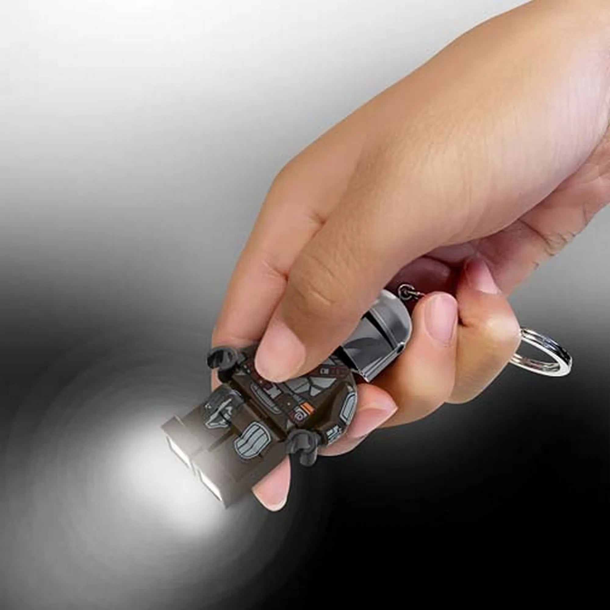 LEGO Mandalori LED-es kulcstartó használat közben, a minifigura lábaiból előtörő erős LED-fénnyel.