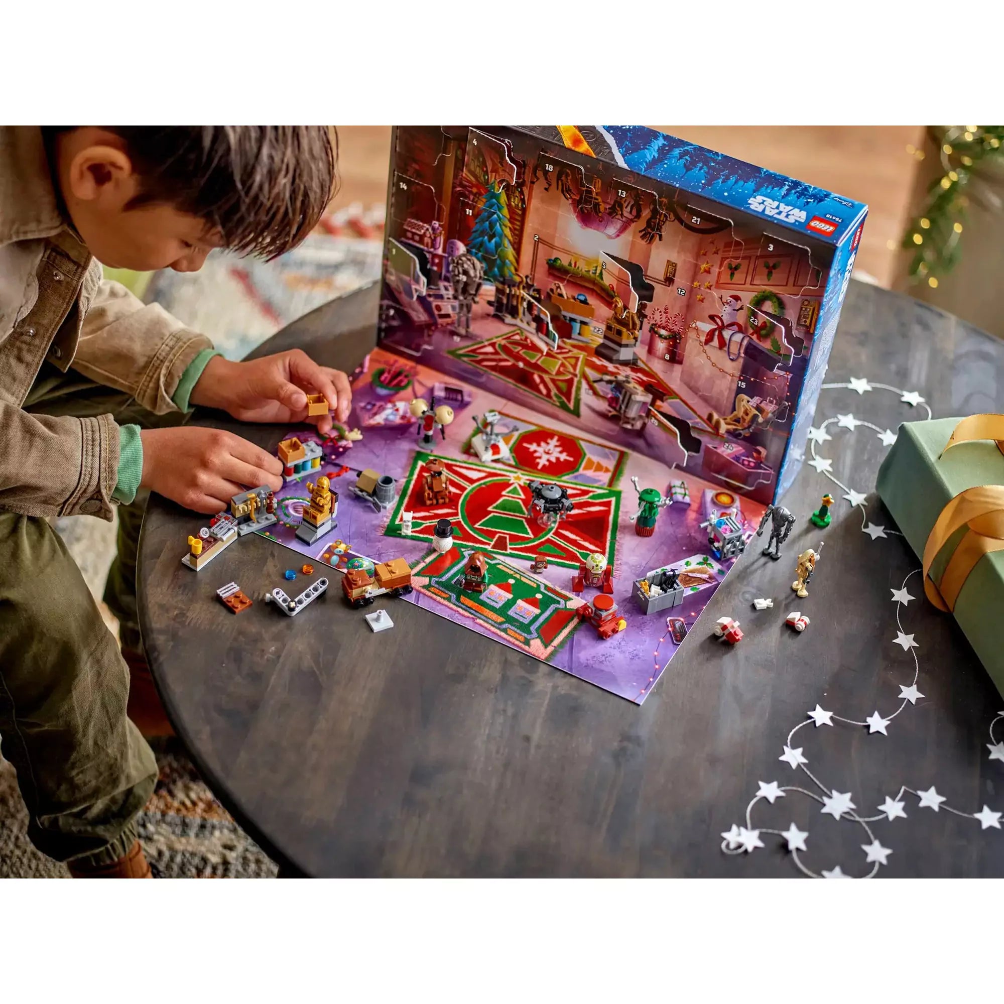 Kisfiú a LEGO Star Wars Adventi naptár 2025 figuráival és miniépítményeivel játszik, ünnepi droidműhely hátterű adventi kalendáriummal.