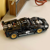 Megépített LEGO Technic 1966 Ford GT40 MKII versenyautó asztalon elhelyezve, klasszikus fekete-ezüst dizájnnal és arany színű felnikkel