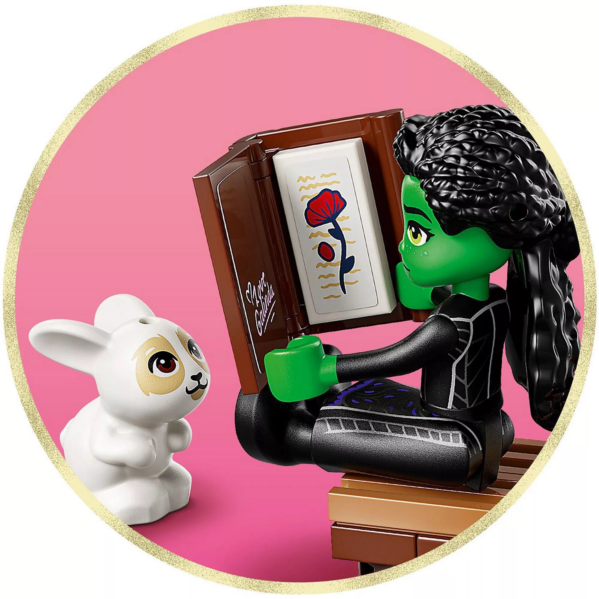 Elphaba minifigura a LEGO Wicked Elphaba’s rejtekhelye (75687) készletből egy varázskönyvet olvas, miközben egy fehér nyuszi figyeli.