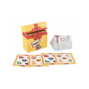 A Meglepi! társasjáték nyitott sárga doboza és a kártyapakli, előtérben kirakott ajándékos illusztrációjú lapokkal.