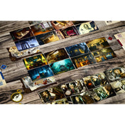 Mysterium társasjáték teljes asztali elrendezése: helyszín-, tárgy- és gyanúsítottkártyák sora, játéktábla, jelölők és víziókártyák egy fa felületen.