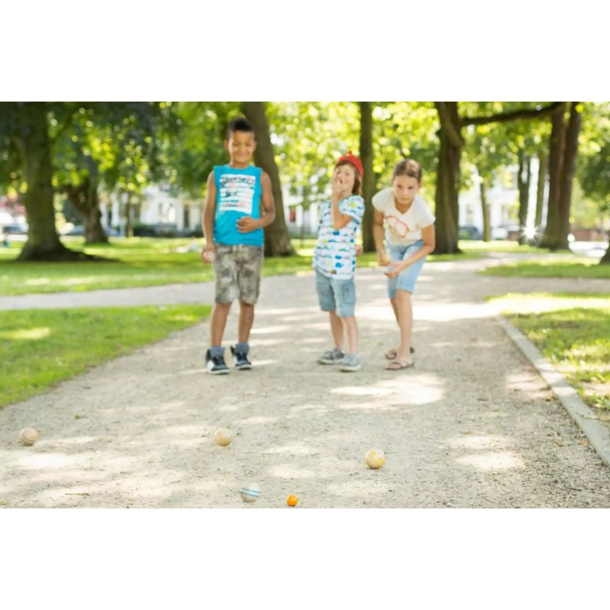 Petanque, ügyességi játék, BS Toys – gyerekek játsszák a fa golyós játékot parkban kavicsos úton.