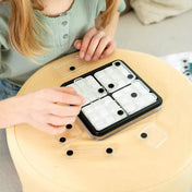 „A Dice Deduction játék használat közben, a játékos átlátszó pontjelölt elemeket helyez a táblára.”