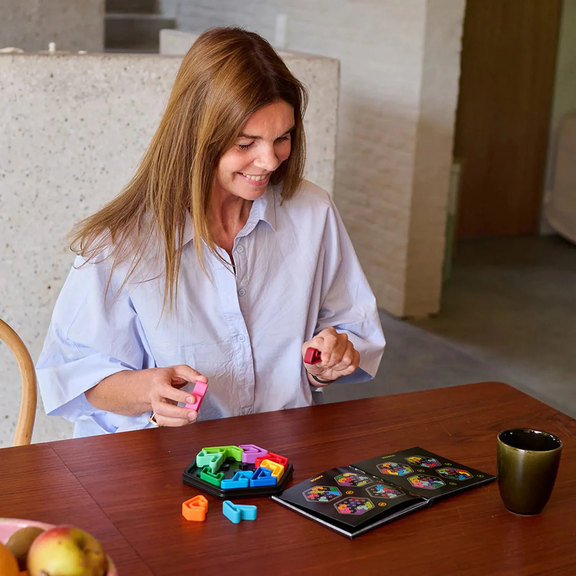 IQ Hexagon logikai játék használat közben, felnőtt játékos színes elemeket helyez a játéktáblára.